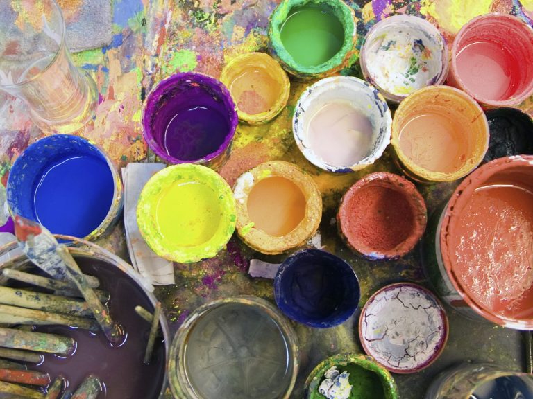 goldhorizont-farbtoepfe.jpg Viele bunte geöffnete Farbtoepfe und Pinsel